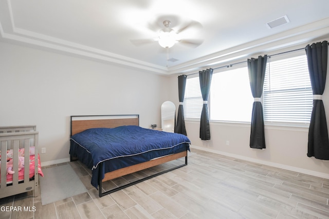 10716 Drew Pearson Dr, El Paso, TX 79924 - bedroom with ceiling fan, baseboards, a tray ceiling, and light wood-style floors