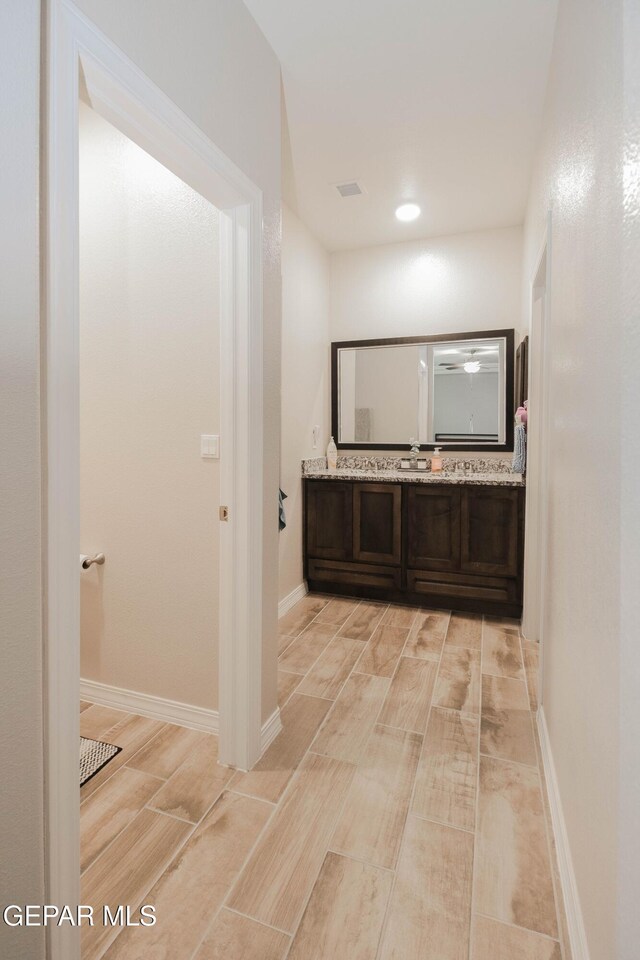 10716 Drew Pearson Dr, El Paso, TX 79924 - hallway featuring visible vents, wood finish floors, and a sink