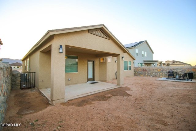 10716 Drew Pearson Dr, El Paso, TX 79924 - back of house with a gate, a patio area, a fenced backyard, and stucco siding