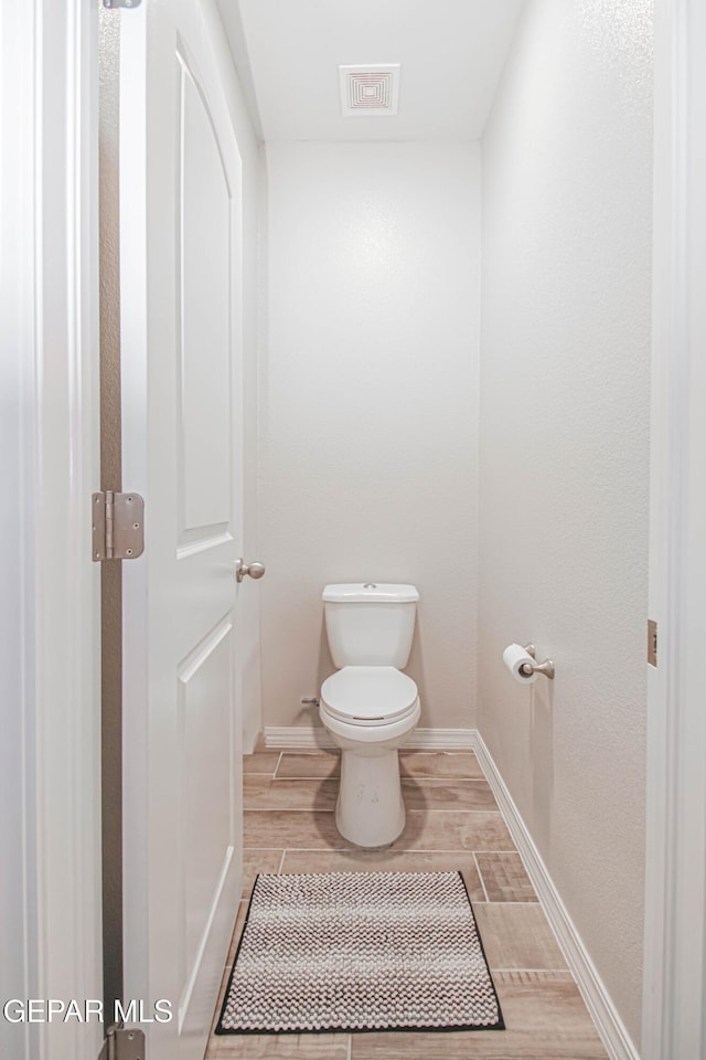 10716 Drew Pearson Dr, El Paso, TX 79924 - bathroom with wood finished floors, visible vents, toilet, and baseboards
