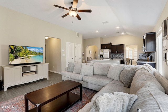 living room with ceiling fan, vaulted ceiling, dark wood-style floors, and visible vents