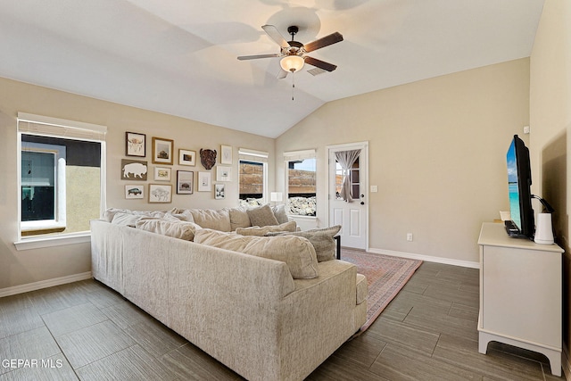 living area featuring baseboards, ceiling fan, and vaulted ceiling