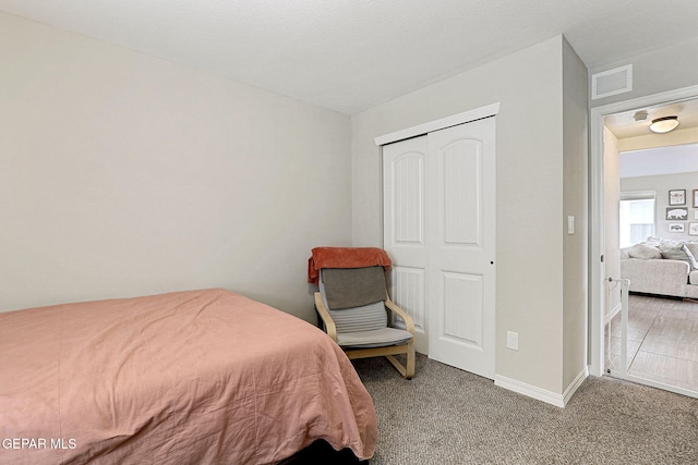 carpeted bedroom with baseboards, a closet, and visible vents