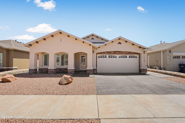 mediterranean / spanish home with concrete driveway, a garage, stone siding, and stucco siding