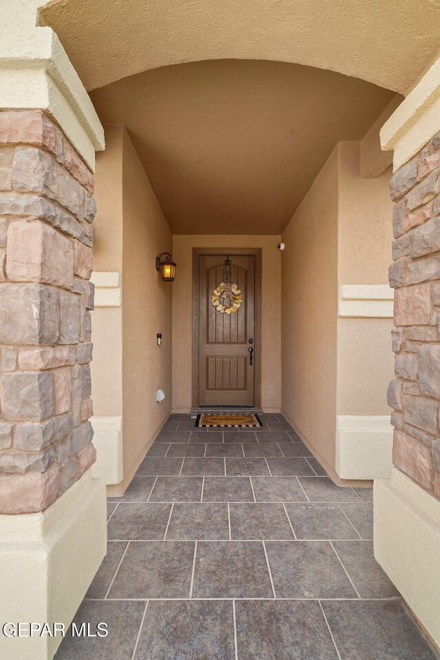 entrance to property with stone siding and stucco siding