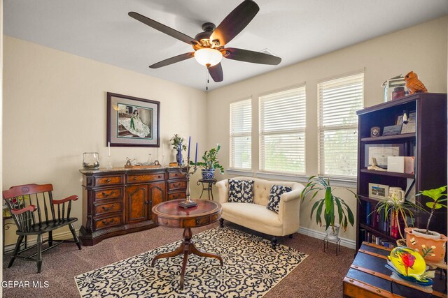 living area with carpet, a ceiling fan, and baseboards