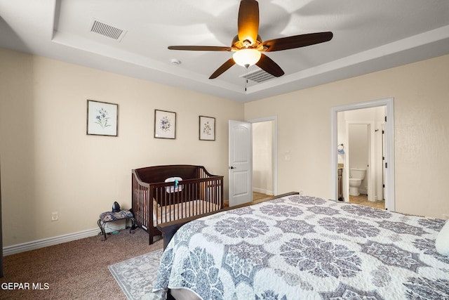 bedroom with carpet flooring, baseboards, visible vents, and a raised ceiling