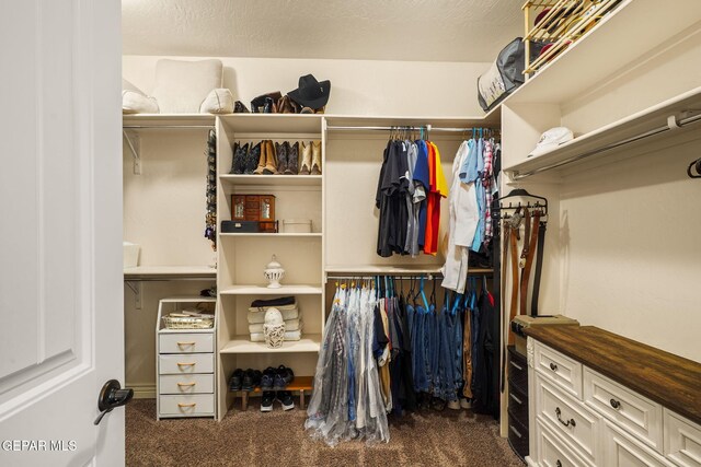 walk in closet featuring dark carpet
