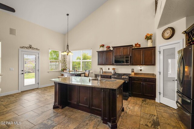 kitchen featuring a sink, light stone countertops, baseboards, appliances with stainless steel finishes, and high vaulted ceiling