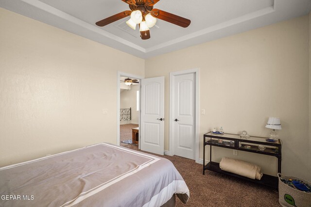 bedroom with a ceiling fan, carpet flooring, and a raised ceiling