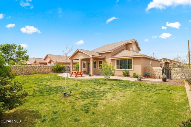 back of property featuring roof with shingles, a fenced backyard, a yard, a patio, and stucco siding