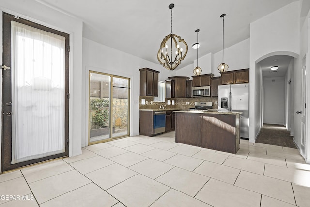14218 Charles Pollock Ave, El Paso, TX 79938 - kitchen featuring stainless steel appliances, dark brown cabinetry, backsplash, a kitchen island, and arched walkways