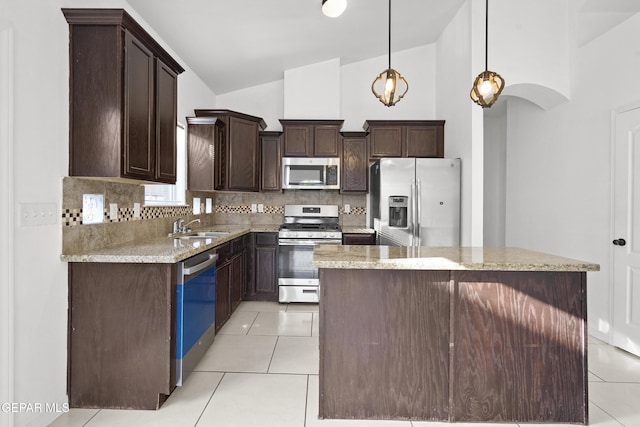 14218 Charles Pollock Ave, El Paso, TX 79938 - kitchen featuring stainless steel appliances, dark brown cabinets, tasteful backsplash, light tile patterned floors, and a kitchen island
