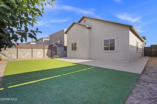 14218 Charles Pollock Ave, El Paso, TX 79938 - back of property featuring a storage unit, a patio area, a fenced backyard, and stucco siding