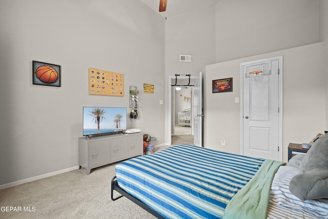 bedroom with a towering ceiling, light carpet, and baseboards