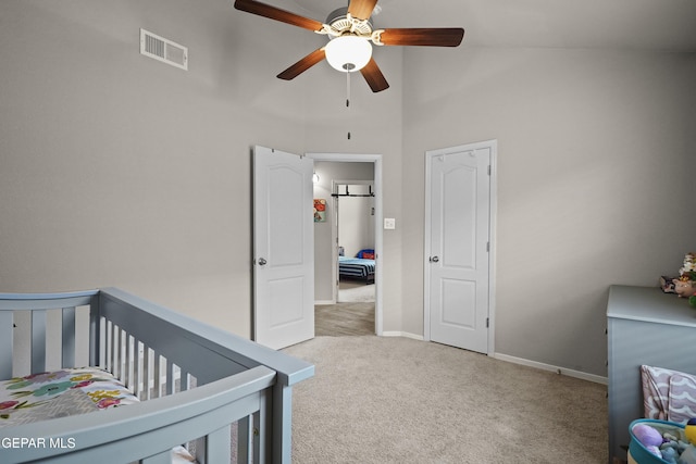 bedroom featuring carpet floors, a towering ceiling, baseboards, a ceiling fan, and a crib