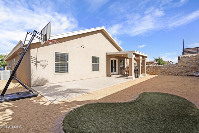 rear view of house featuring a patio, stucco siding, and french doors