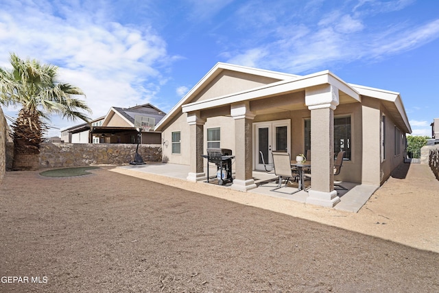 back of property with stucco siding, a patio area, and a fenced backyard