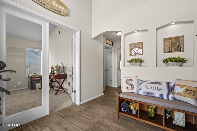 hallway with arched walkways and baseboards