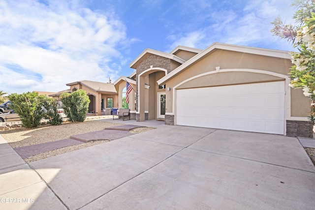 view of front facade with stone siding, stucco siding, driveway, and an attached garage