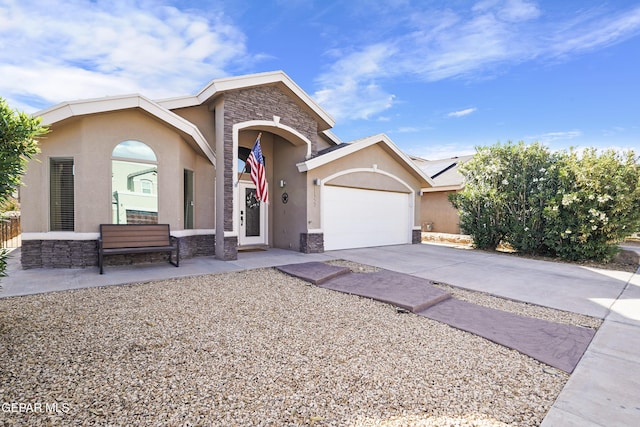 view of front of house with stone siding, stucco siding, concrete driveway, and an attached garage
