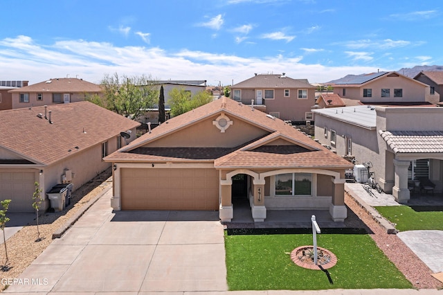 mediterranean / spanish house with an attached garage, stucco siding, driveway, and a residential view