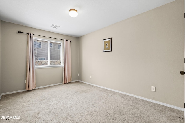 carpeted spare room featuring visible vents and baseboards