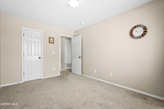 unfurnished bedroom featuring baseboards, carpet flooring, and visible vents