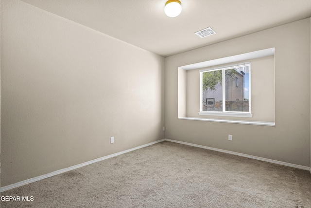 carpeted empty room featuring baseboards and visible vents