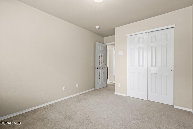 unfurnished bedroom with carpet floors, baseboards, and a closet