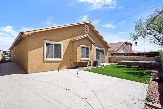 back of property with a patio area, fence, cooling unit, a yard, and stucco siding