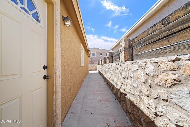view of side of property featuring fence and stucco siding