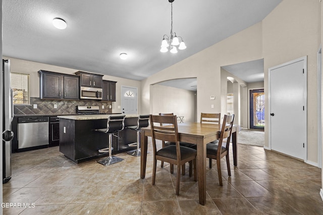 dining space with arched walkways, baseboards, high vaulted ceiling, and a notable chandelier