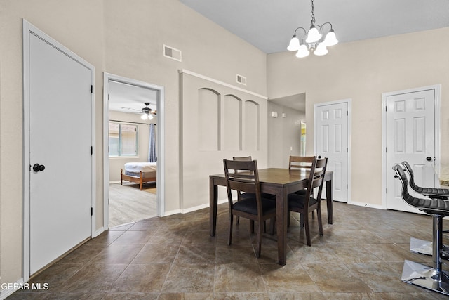 dining room with visible vents, baseboards, a towering ceiling, and ceiling fan with notable chandelier