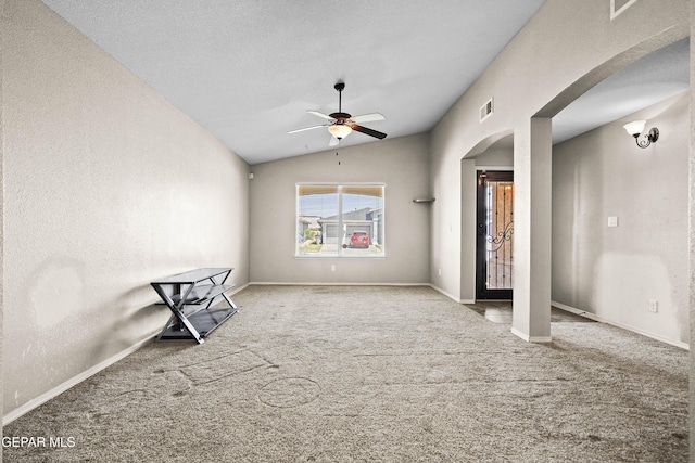 unfurnished room featuring ceiling fan, carpet floors, arched walkways, vaulted ceiling, and visible vents