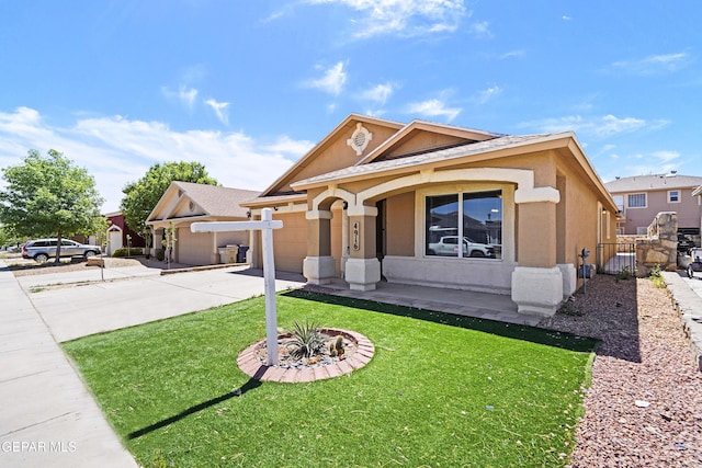 view of front of property with covered porch, driveway, a front yard, an attached garage, and stucco siding