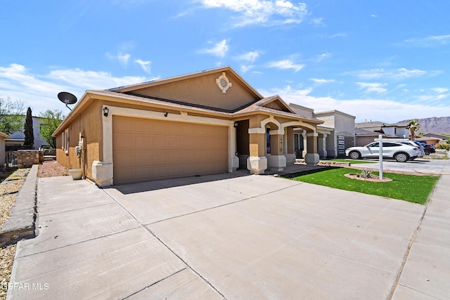 view of front of property featuring an attached garage, stucco siding, and driveway