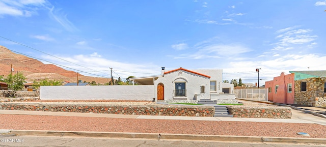 mediterranean / spanish-style house featuring a fenced front yard and stucco siding