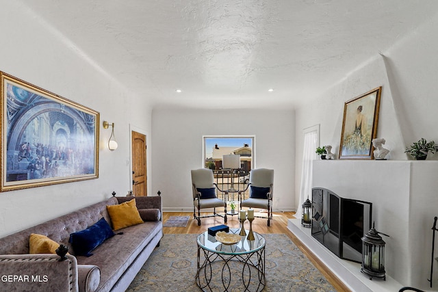living area featuring recessed lighting, a textured ceiling, and wood finished floors