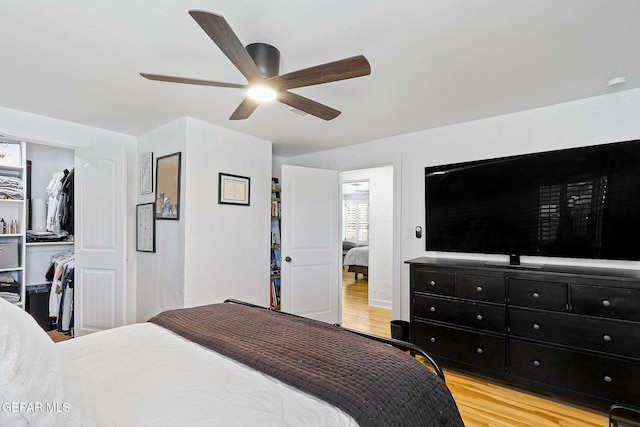 bedroom featuring light wood-style floors, ceiling fan, and a closet