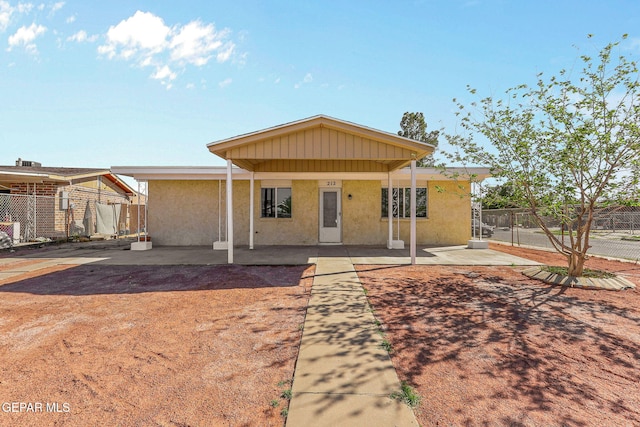 view of front of house featuring a patio, stucco siding, and fence
