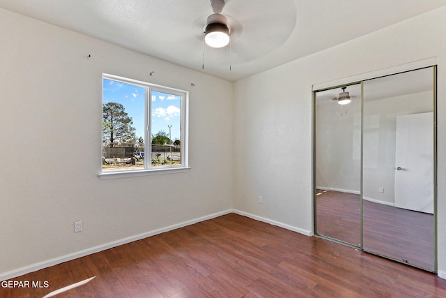 unfurnished bedroom featuring a closet, a ceiling fan, wood finished floors, and baseboards