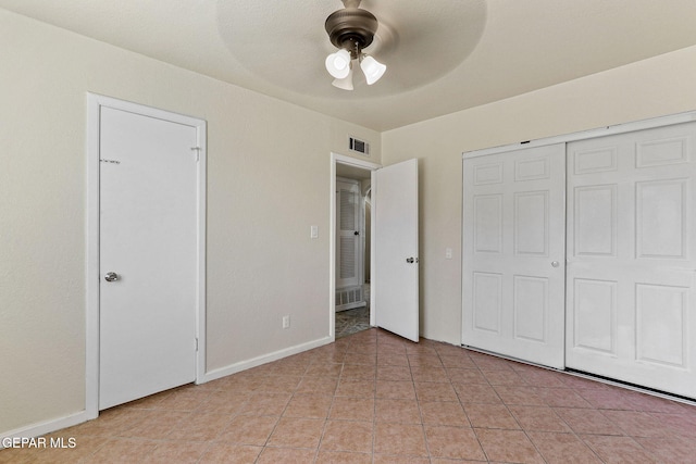 unfurnished bedroom featuring light tile patterned flooring, visible vents, ceiling fan, and baseboards