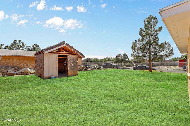 view of yard featuring an outbuilding, a storage shed, and a fenced backyard