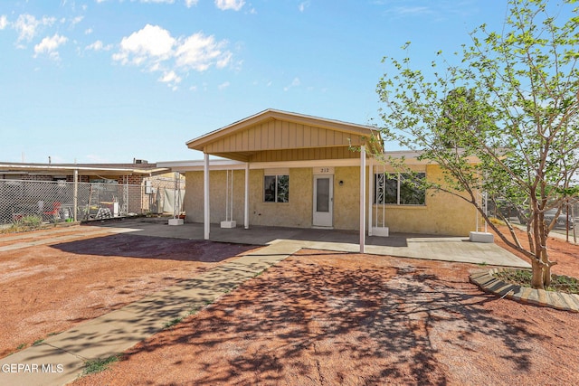 back of house with fence, stucco siding, and a patio area