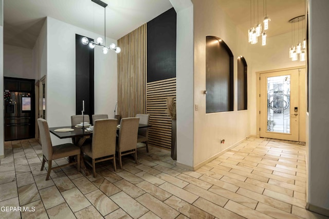dining space featuring arched walkways, baseboards, and a notable chandelier