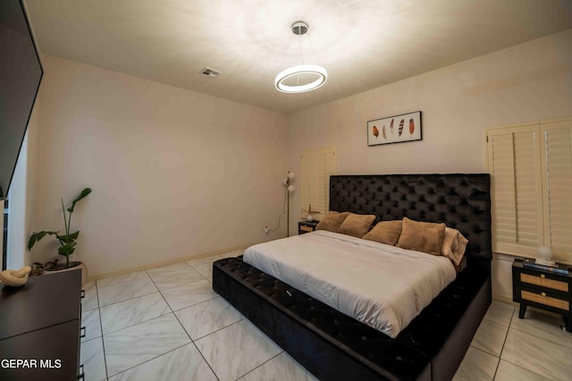 bedroom featuring baseboards and visible vents