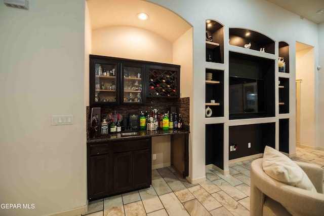 bar featuring bar area, marble finish floor, and built in features