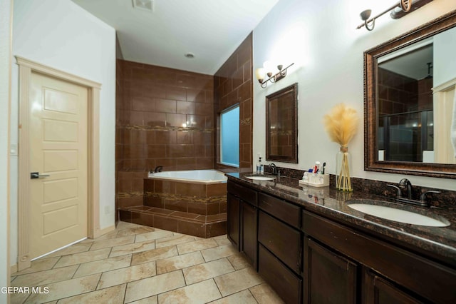 full bathroom with a garden tub, a shower with door, a sink, and double vanity