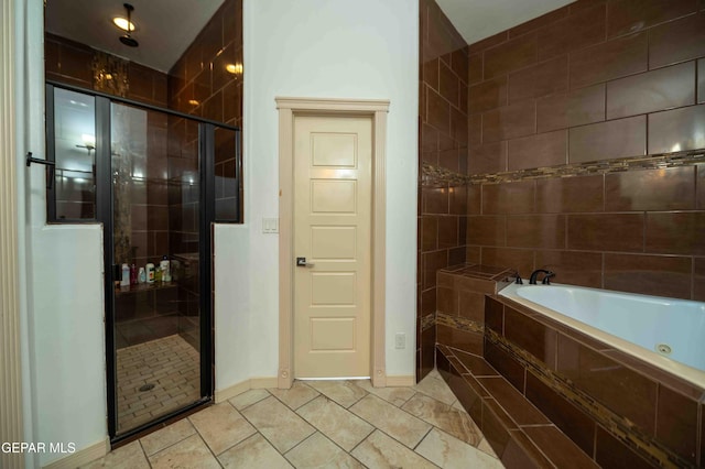 full bathroom featuring a shower stall, a garden tub, tile patterned flooring, and baseboards